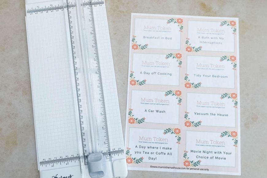 Free Printable Mother's Day Coupon Book being cut with a paper trimmer