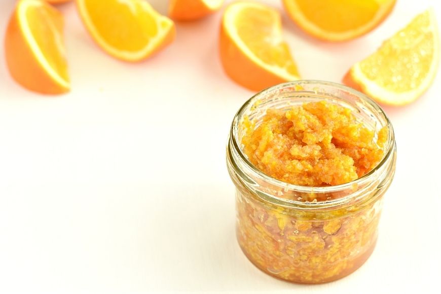 A jar of homemade salt scrub and orange segments