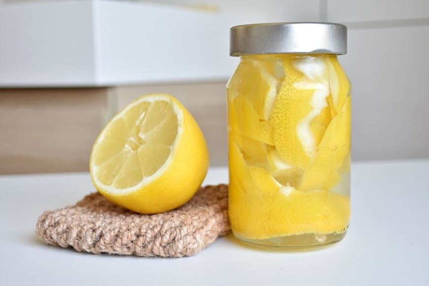 A jar of lemon peels and white vinegar 