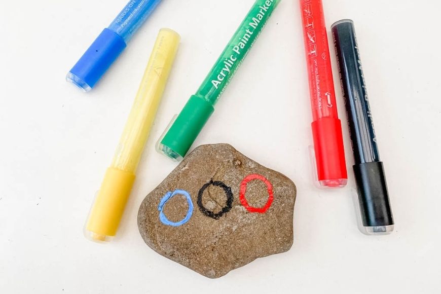 A rock with three of the olympic rings painted on 