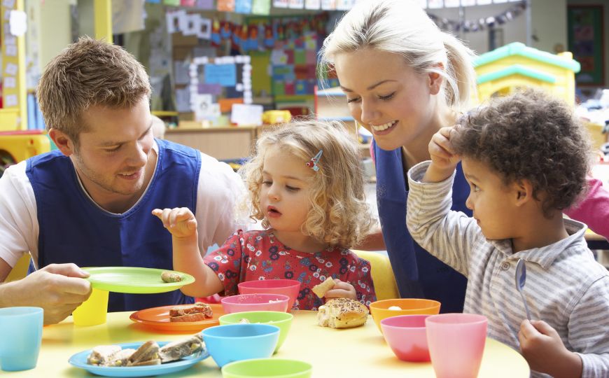 2 children and 2 adults counting food onto plates